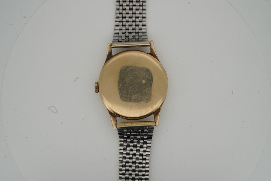A gentleman's late 1940's 9ct gold Omega manual wind wrist watch, with baton and quarterly Arabic numerals and subsidiary seconds, movement c.265, case diameter 33mm, no logo on winding crown, on an associated stainless